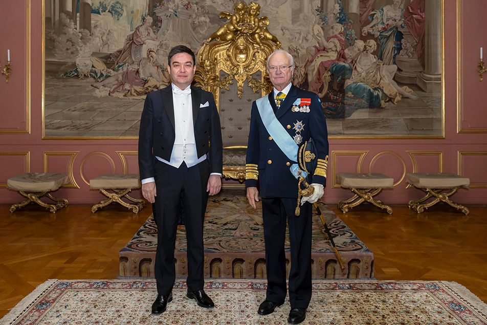 Le roi Carl Gustav de Suède et Nodir Ganiev, ambassadeur d'Ouzbékistan en Suède, dans un décor luxueux. Personne n'a l'air content d'être là